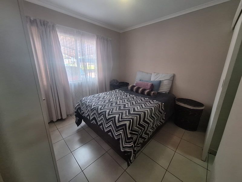 A functional bedroom featuring tiled flooring and a built-in cupboard, offering a neutral base for personalization.