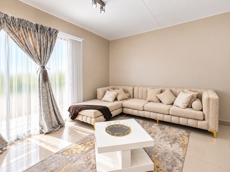A bright and modern living room featuring large sliding glass doors that provide ample natural light and access to the outdoor area.