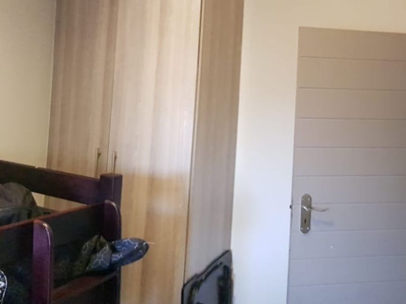 A bedroom featuring a built-in wardrobe and a modern internal door, providing functional storage and access.