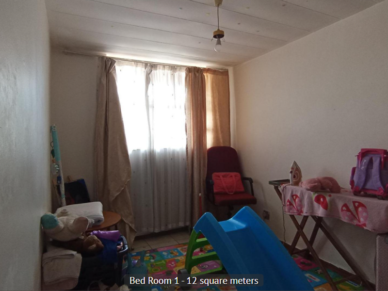 A bedroom measuring 12 square meters featuring a window with curtains and a central ceiling light fixture.