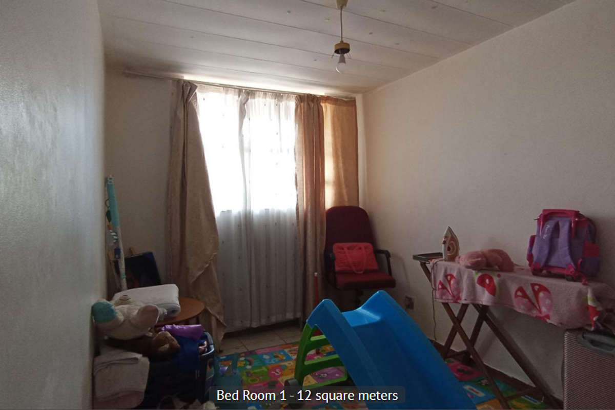A bedroom measuring 12 square meters featuring a window with curtains and a central ceiling light fixture.