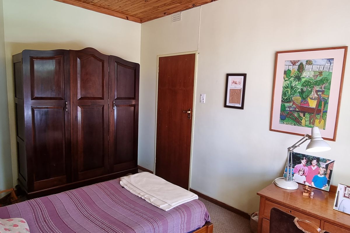 A bedroom featuring a timber-paneled ceiling, carpeted flooring, and a standard interior door.