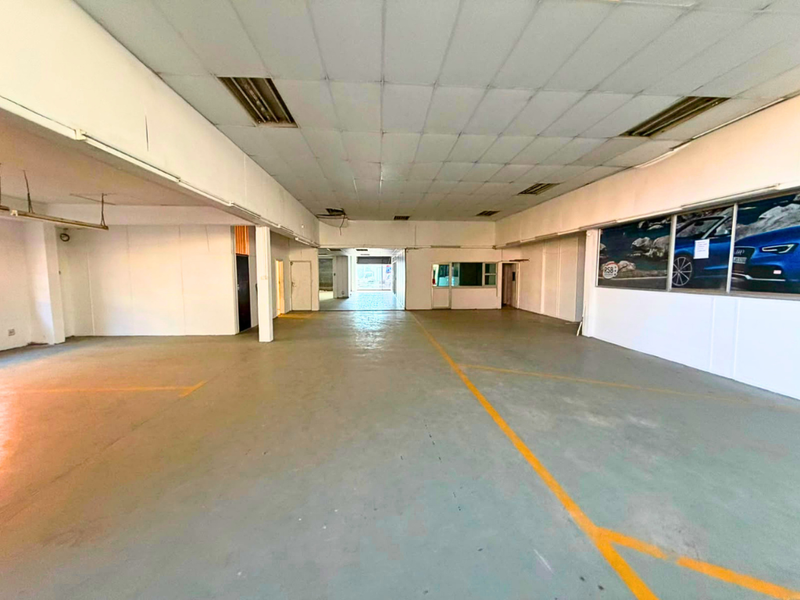 Spacious industrial utility area featuring a suspended ceiling, recessed lighting, and durable concrete flooring, suitable for various commercial or storage applications.