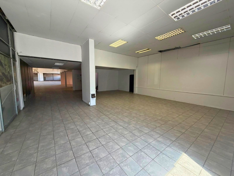 Spacious open-plan industrial unit featuring ceramic tile flooring, suspended ceilings with integrated lighting, and a large open layout suitable for various commercial uses.