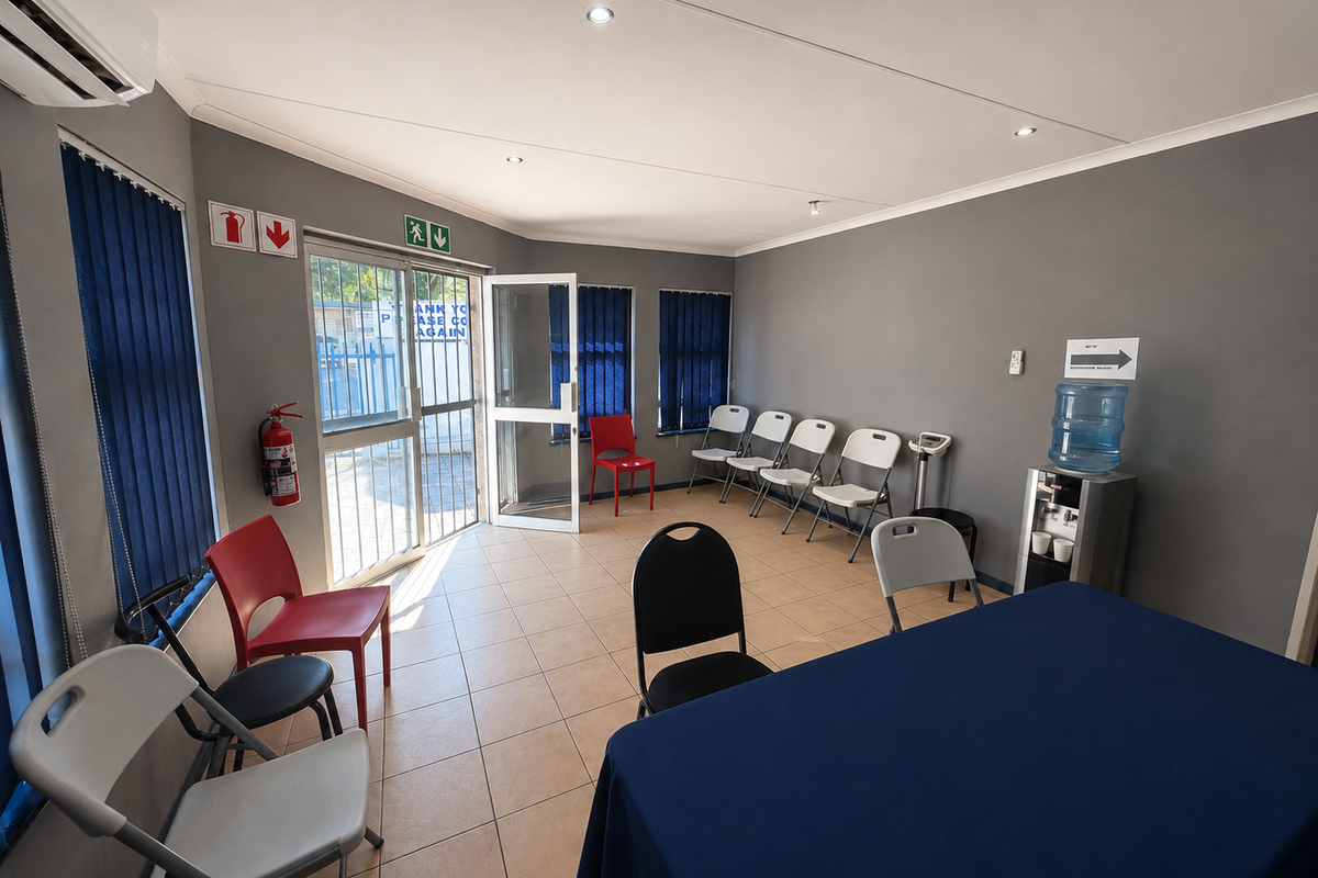 A functional office or waiting area featuring tiled flooring, recessed lighting, air conditioning, and large windows with vertical blinds.