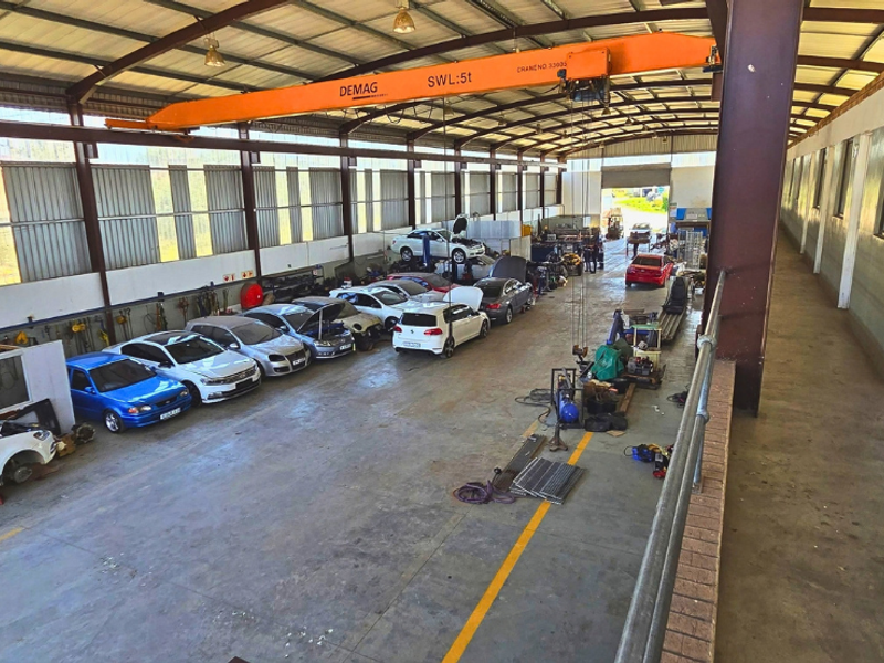 Spacious industrial workshop featuring a high-clearance steel structure, concrete flooring, and an integrated overhead gantry crane for heavy-duty operations.