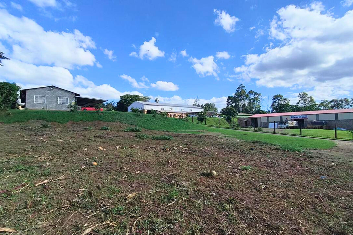 Wide-angle view of the industrial property grounds featuring multiple warehouse structures and open land area.