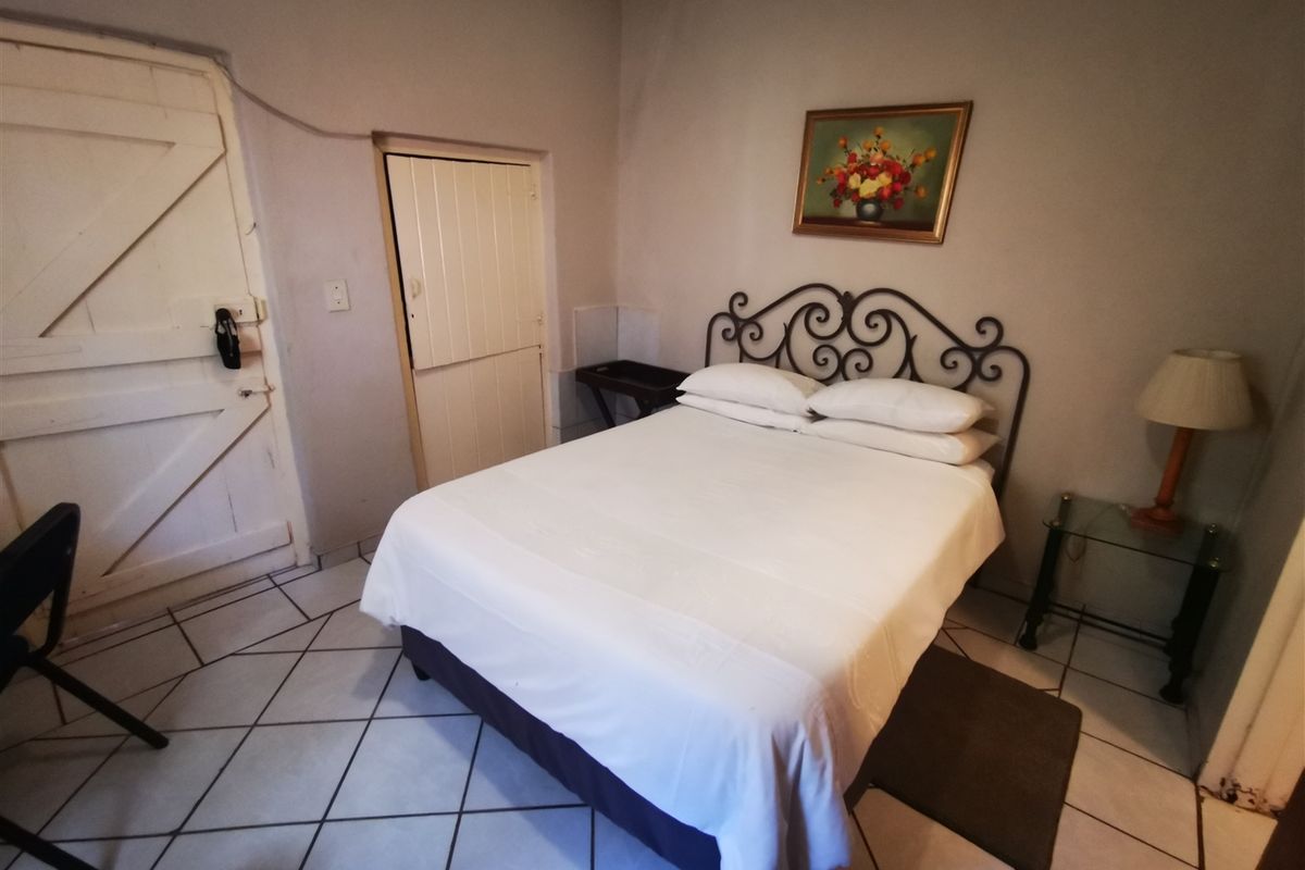 A bedroom featuring tiled flooring and two internal doors, including a stable-style door. The space requires cosmetic updates to improve its overall condition.