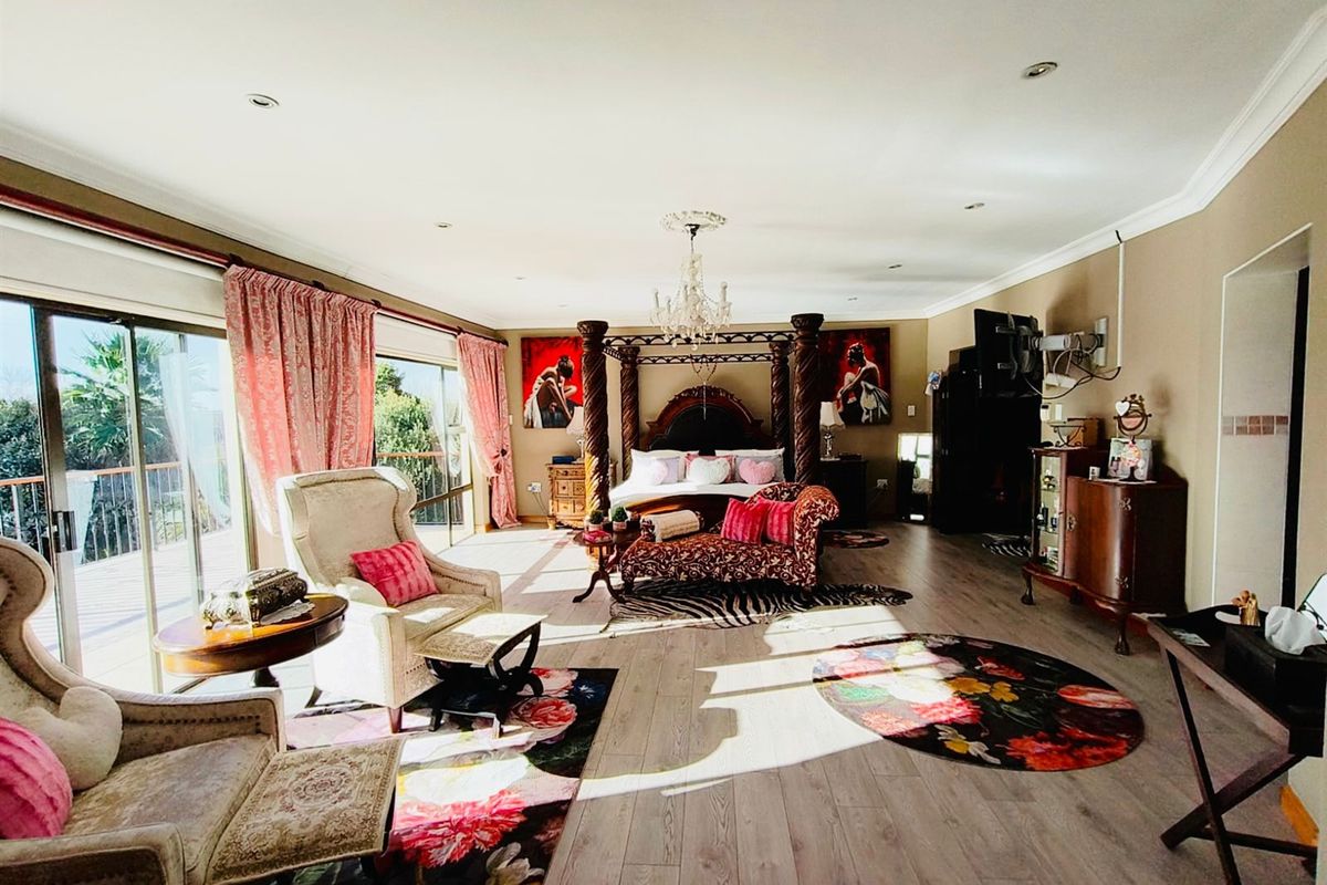 Spacious bedroom featuring laminate flooring, recessed downlighting, and large sliding glass doors providing access to an outdoor area.