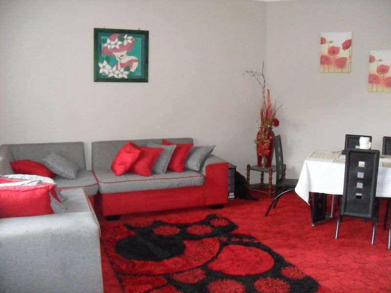 An open-plan living and dining area featuring wall-to-wall carpeting and neutral wall finishes.