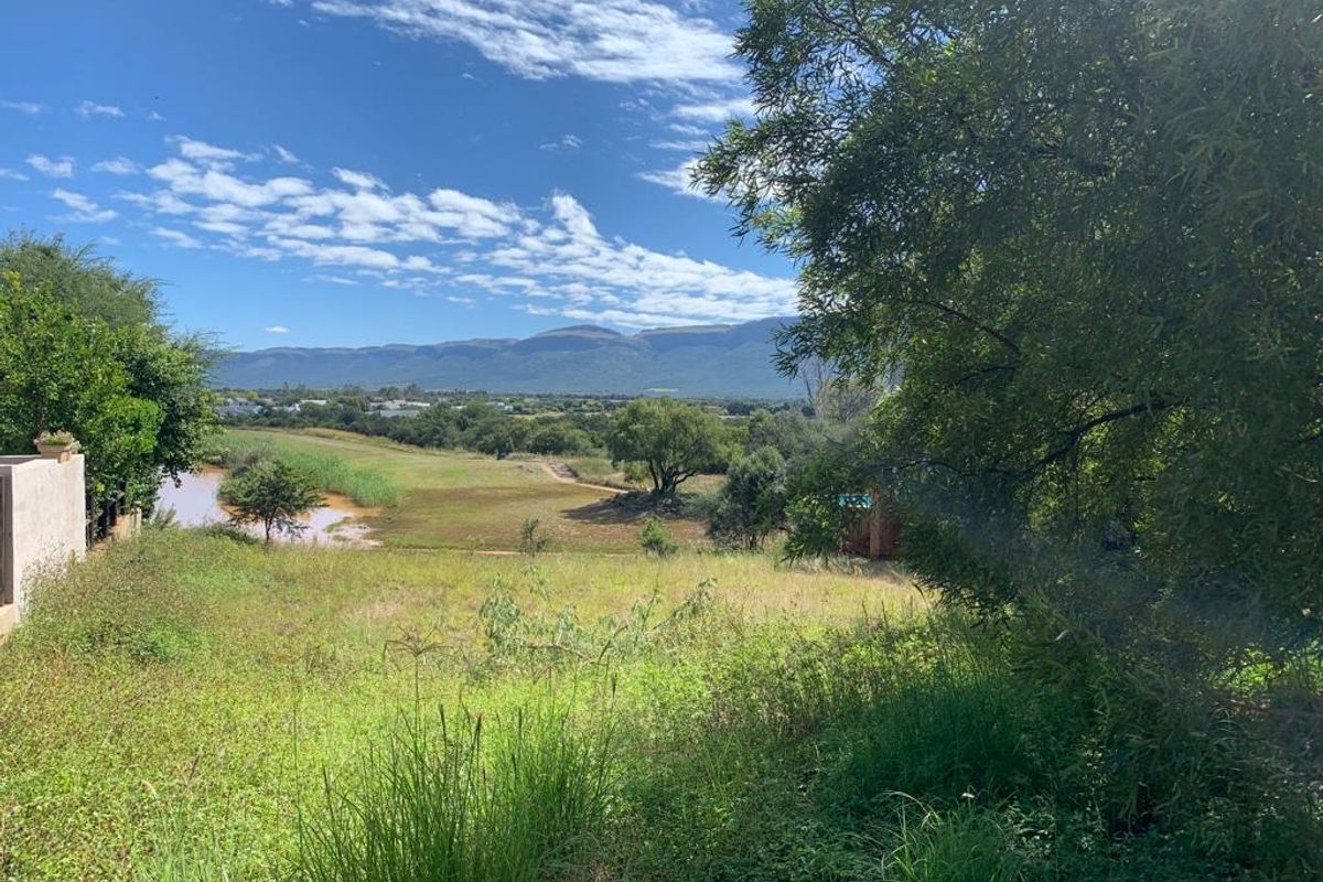 A scenic view overlooking a natural landscape with a water body and distant mountain range, showcasing the property's tranquil outdoor setting.