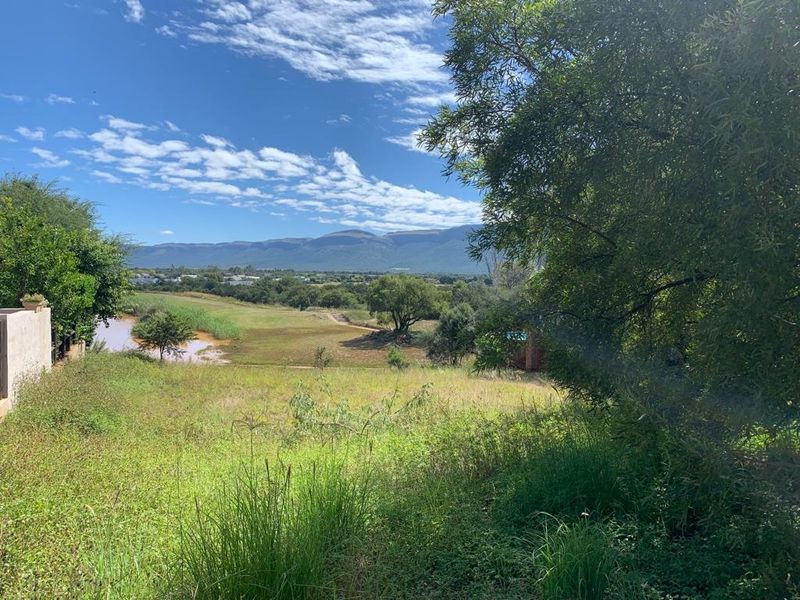 A scenic view overlooking a natural landscape with a water body and distant mountain range, showcasing the property's tranquil outdoor setting.
