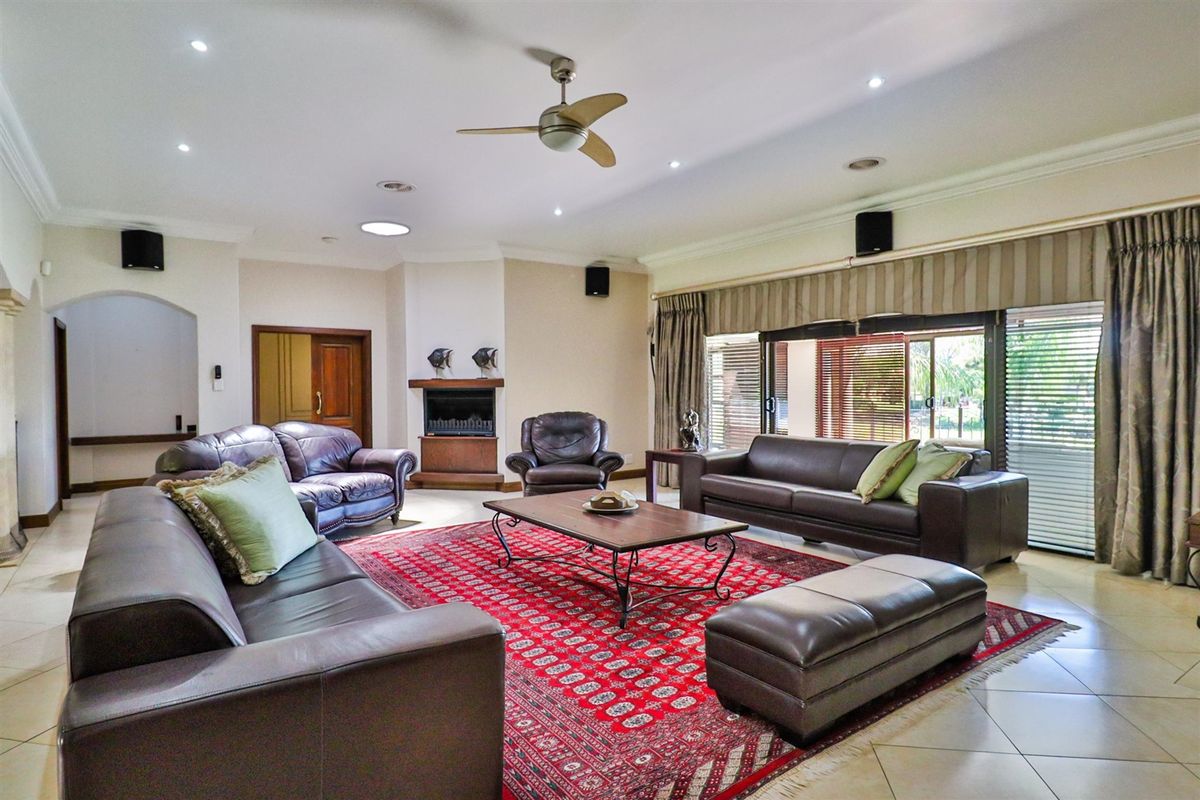 Spacious living room featuring tiled flooring, a built-in fireplace, recessed lighting, and large sliding glass doors providing access to the outdoor area.