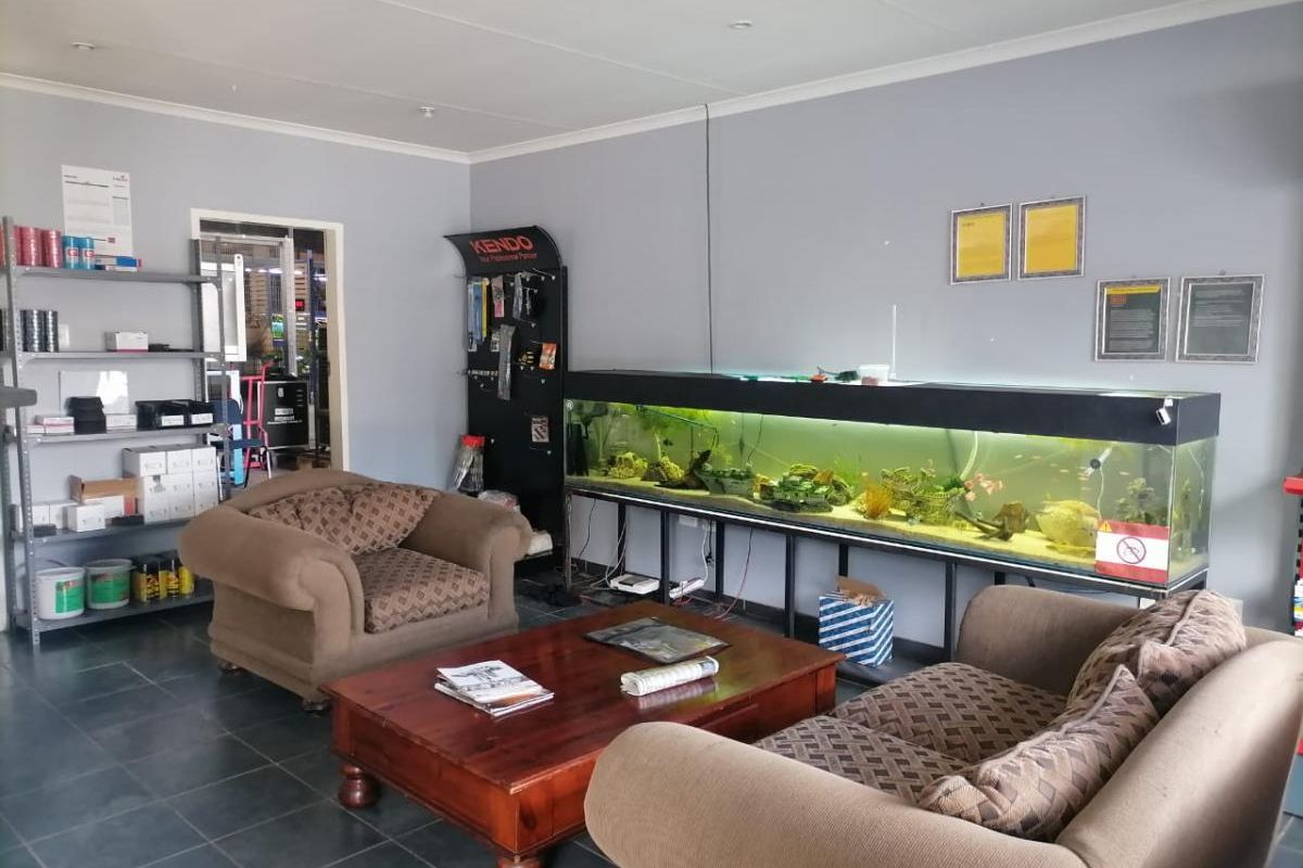 A functional waiting or reception area featuring tiled flooring, neutral wall finishes, and built-in shelving units.