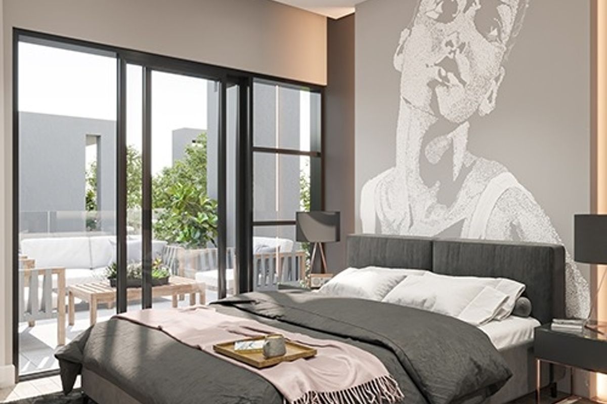 Modern bedroom featuring large sliding glass doors that open onto a private balcony, providing ample natural light and a seamless indoor-outdoor flow.