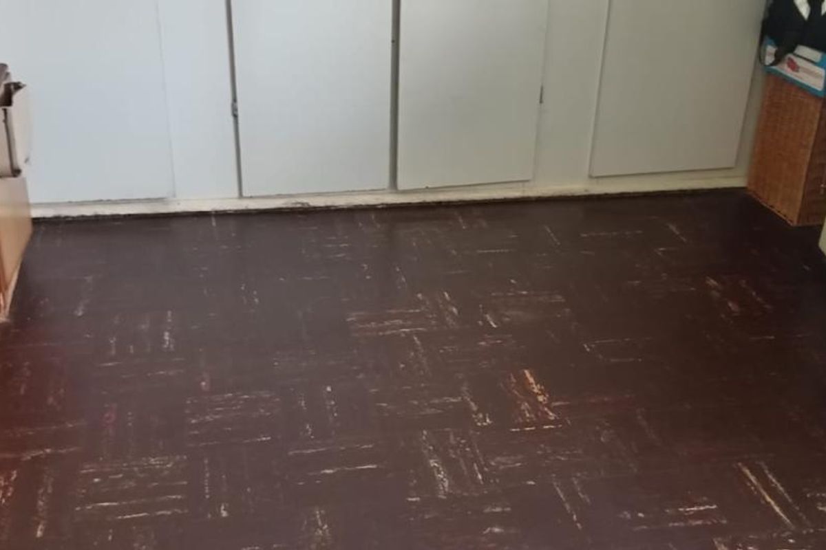 A functional room featuring dark parquet-style flooring and built-in storage cabinetry, offering a blank canvas for potential renovation or interior updates.