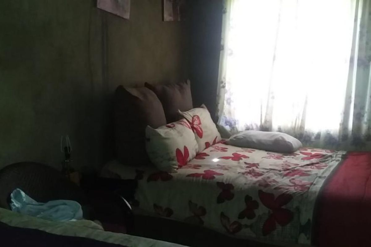A bedroom featuring a window with curtains and basic wall finishes.