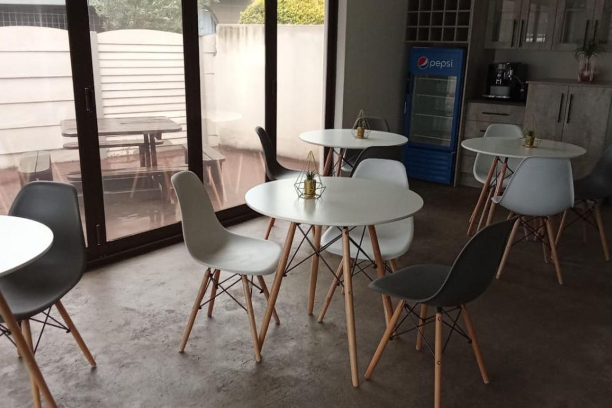 An open-plan entertainment or dining area featuring large glass sliding doors, concrete flooring, and built-in cabinetry with a beverage cooler.