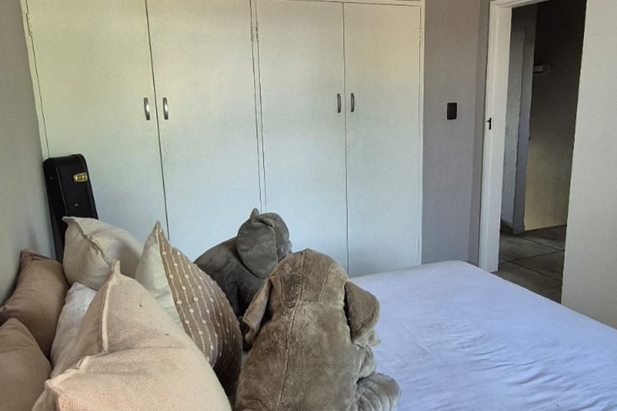 A bedroom featuring built-in floor-to-ceiling cabinetry and tiled flooring, providing ample storage space.