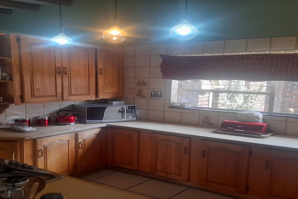 A functional kitchen featuring traditional timber cabinetry, tiled splashbacks, and built-in cooking appliances, offering a classic layout with ample counter space.