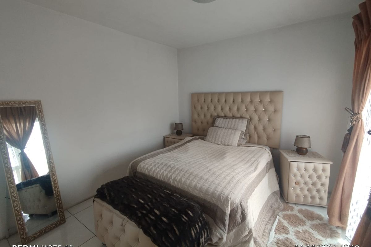 A well-maintained bedroom featuring tiled flooring and neutral wall finishes, providing a comfortable and functional living space.