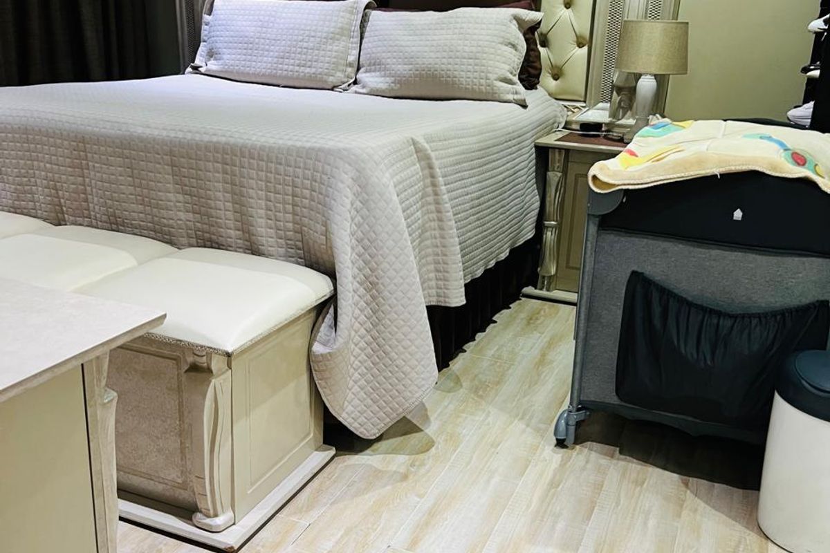 A well-maintained bedroom featuring light-toned wood-look flooring and a neutral color palette, providing a comfortable and functional living space.