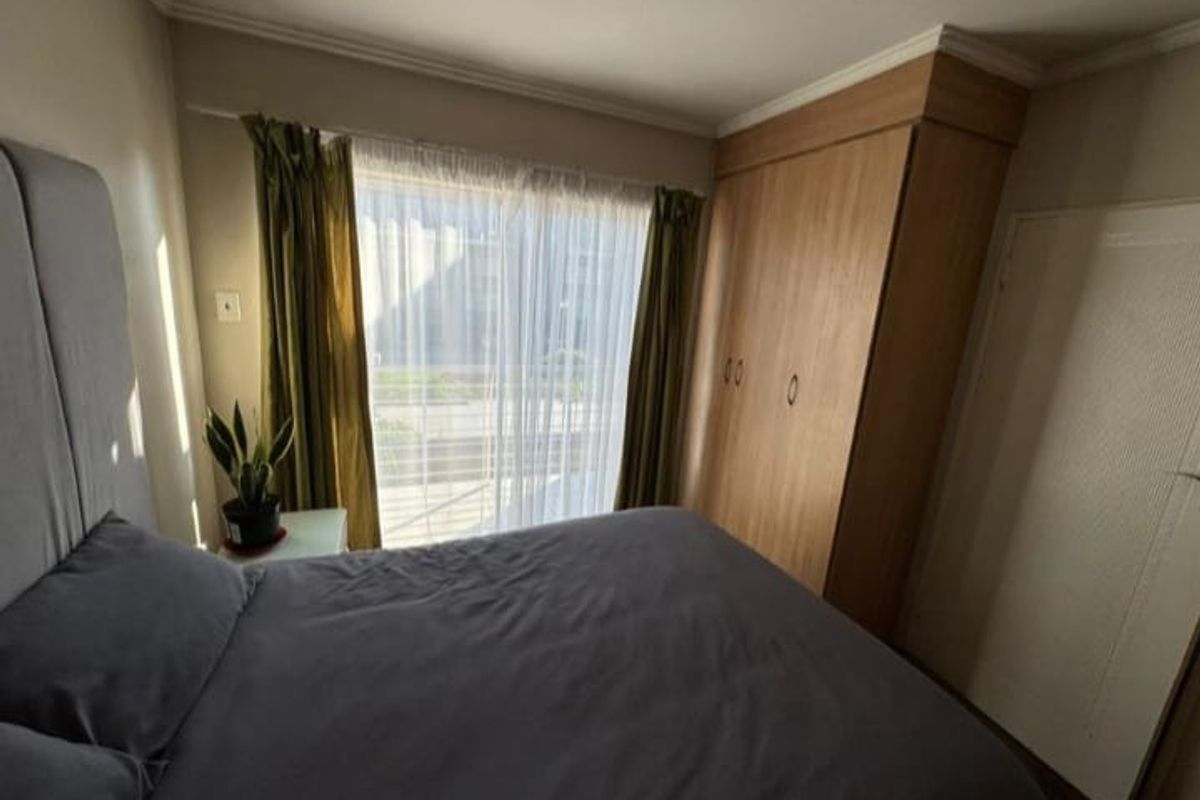 A bedroom featuring built-in wooden cabinetry and a sliding glass door providing access to an outdoor area.