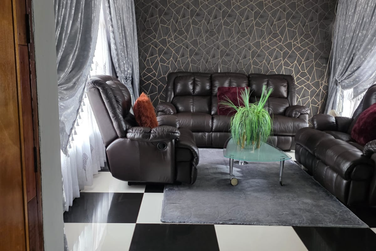 A living room featuring a bold checkered tile floor, recessed ceiling lighting, and a modern geometric feature wall.