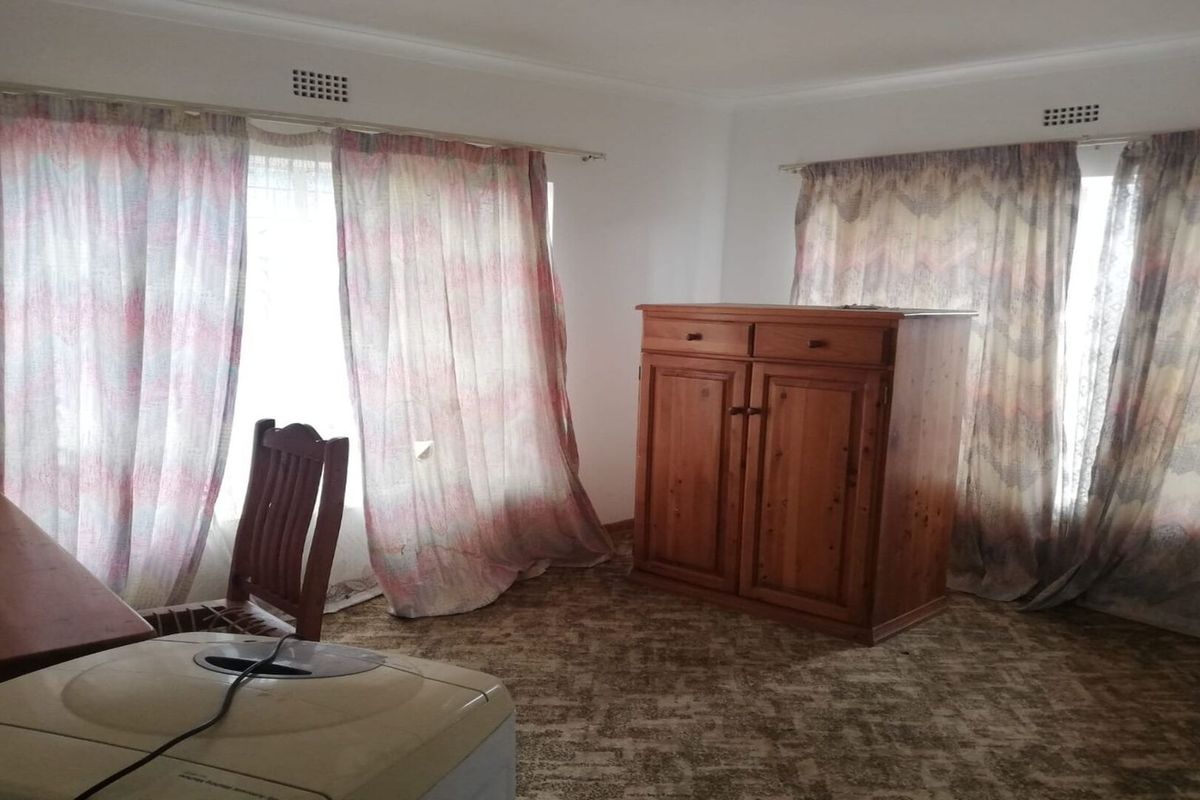 A bedroom featuring carpeted flooring and dual windows with curtains, offering a blank canvas for potential interior updates.