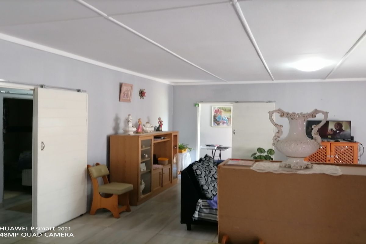 A spacious living area featuring sliding doors, neutral wall tones, and a functional layout suitable for comfortable family living.