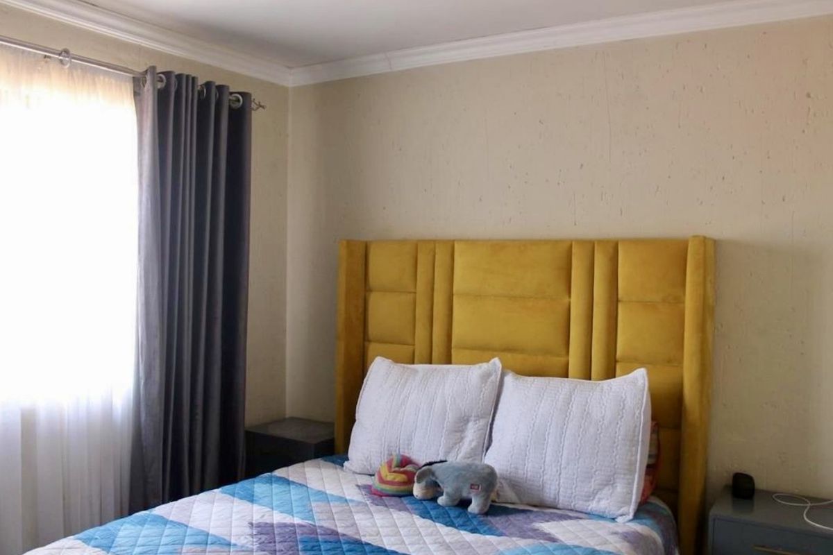A bedroom featuring a window with curtains and a neutral wall finish.