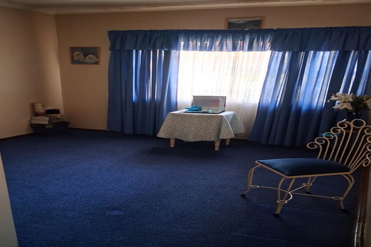 A bedroom featuring blue carpeting and window treatments, offering a blank canvas for potential updates and modernization.