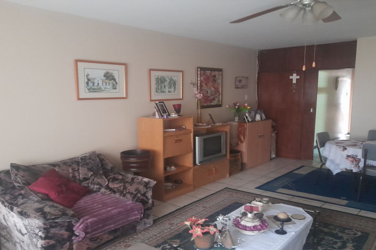 A combined living and dining area featuring tiled flooring and a ceiling fan, providing a functional open-plan layout for daily living.