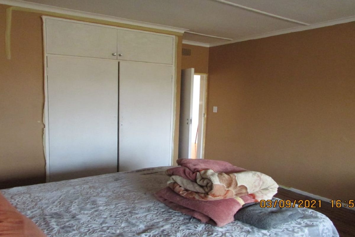 A bedroom featuring built-in cupboards with white doors and neutral wall tones, providing functional storage space.