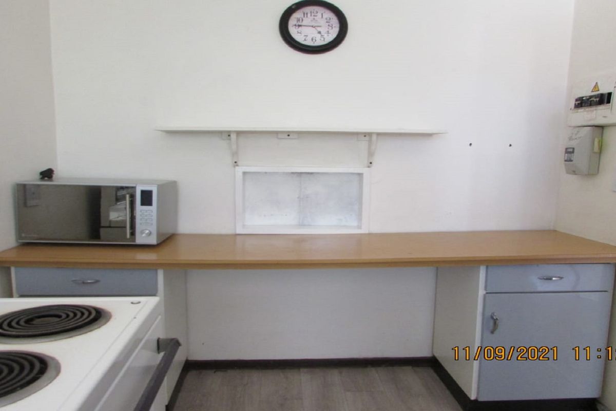A functional kitchen area featuring laminate countertops, built-in cabinetry, and an integrated electric stove, providing a practical workspace for daily meal preparation.