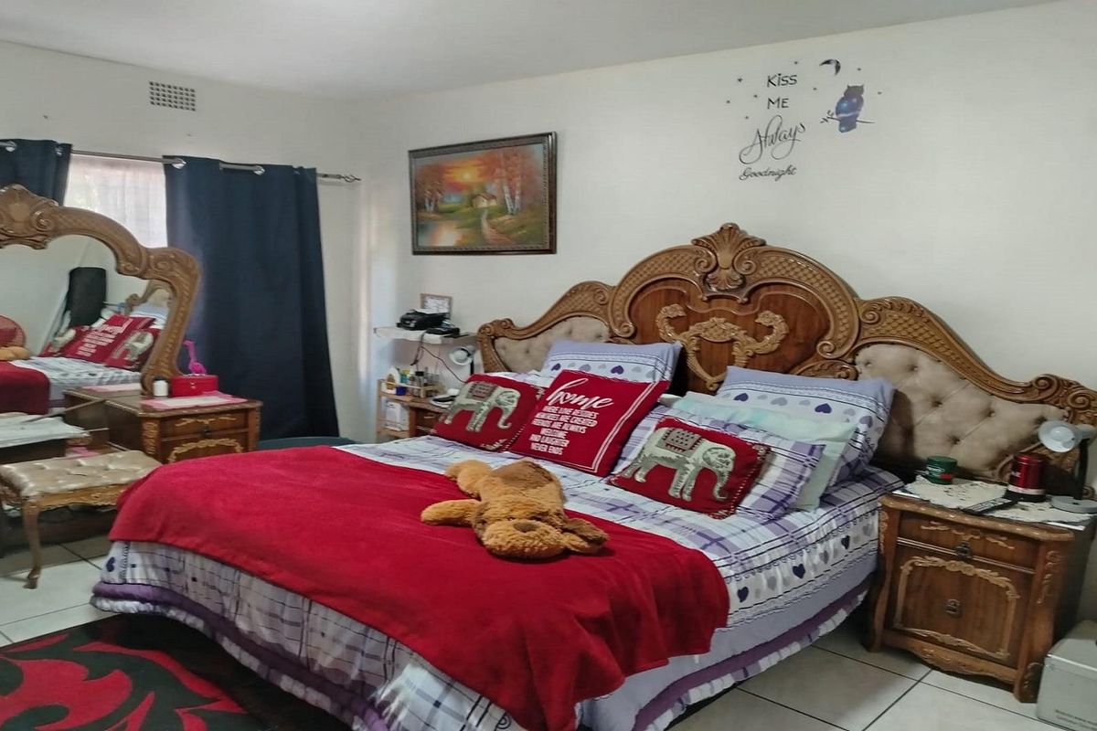 A bedroom featuring tiled flooring and a ventilation grille, providing a functional space for rest.