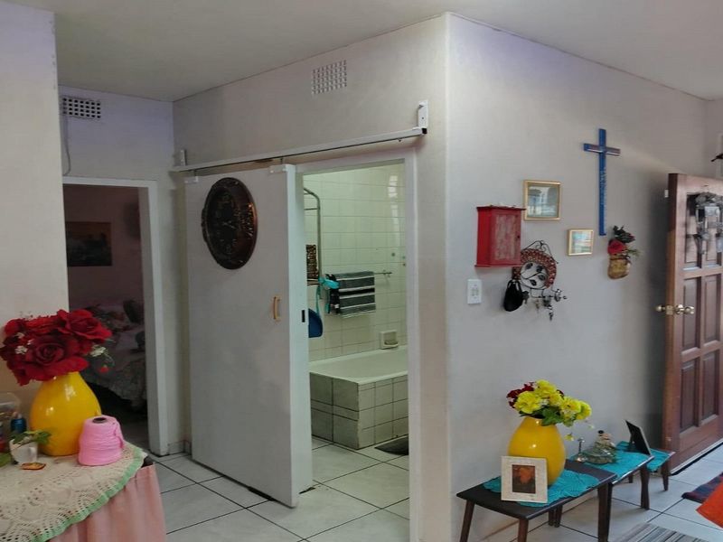 A functional hallway area featuring tiled flooring and access to an adjacent bathroom with a built-in bathtub.