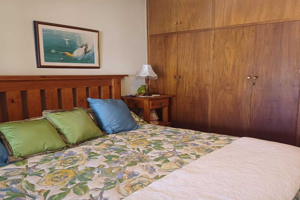 A bedroom featuring built-in wooden cabinetry providing ample storage space.