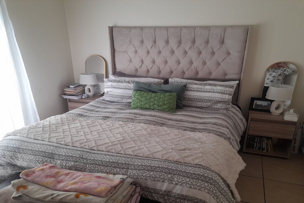 A comfortable bedroom featuring tiled flooring and a neutral color palette, providing a functional and well-maintained sleeping space.