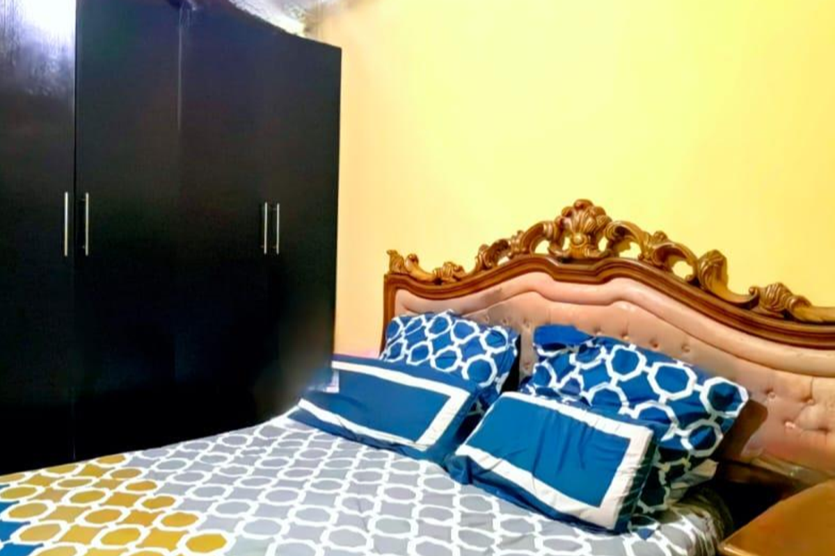 A bedroom featuring a built-in dark wood wardrobe and yellow wall finishes.