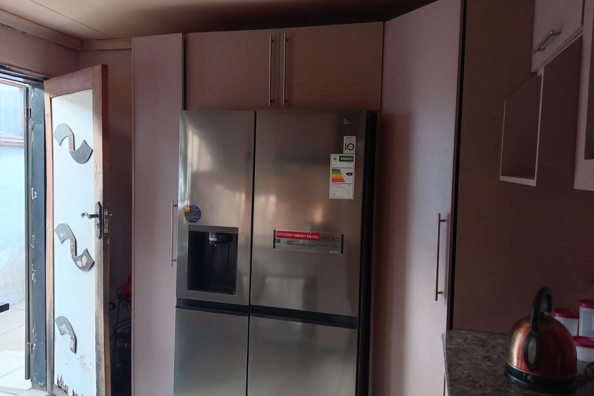 Kitchen area featuring built-in cabinetry and a stainless steel refrigerator, with direct access to an exterior space.