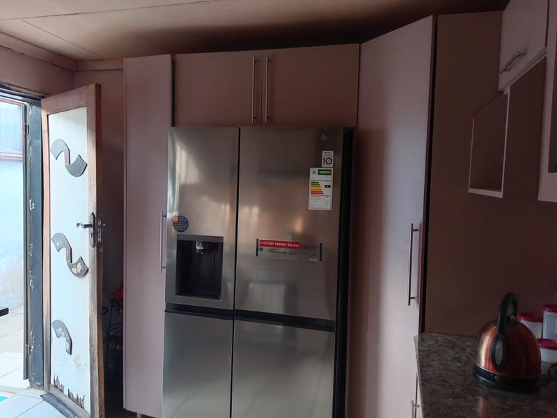 Kitchen area featuring built-in cabinetry and a stainless steel refrigerator, with direct access to an exterior space.