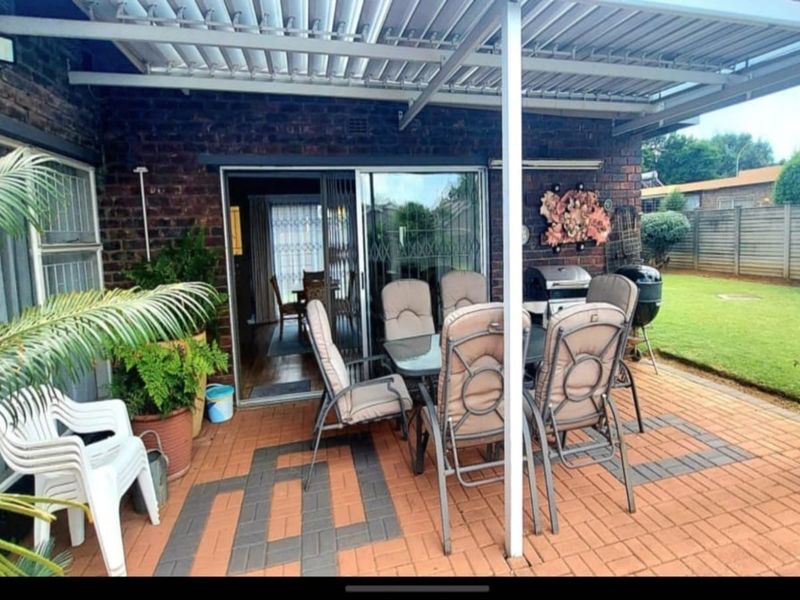 Covered outdoor patio area featuring brick paving, a louvred roof structure, and direct access to the interior through sliding glass doors.