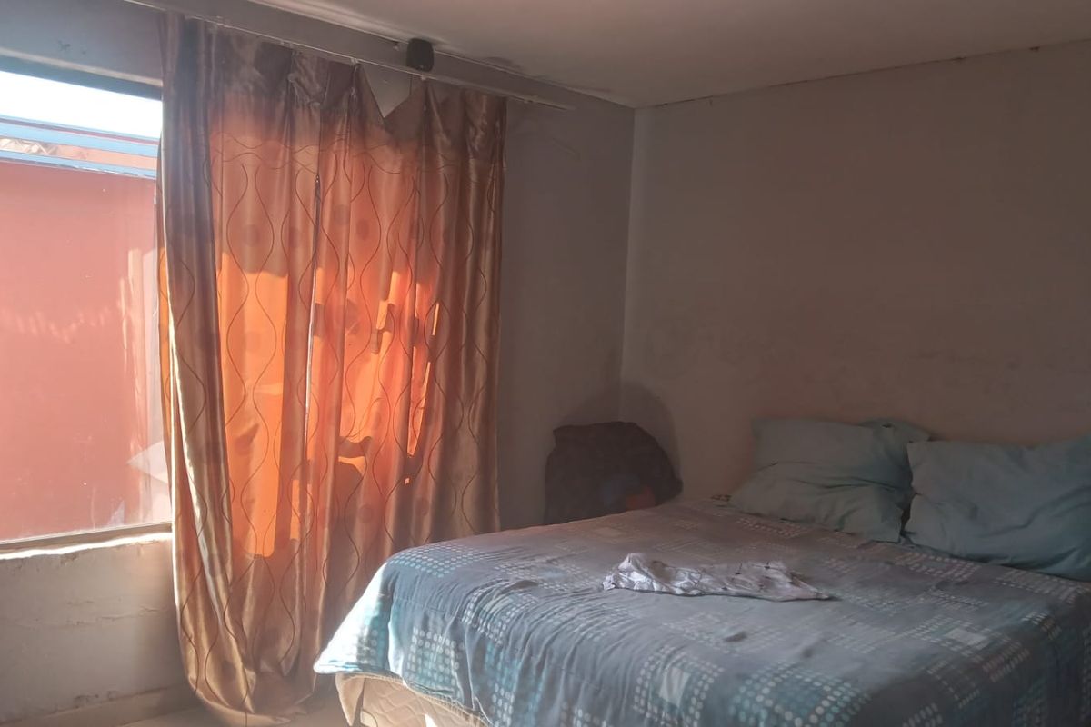 A bedroom featuring a window with a curtain rail, requiring cosmetic updates to the wall finishes to improve the overall aesthetic.