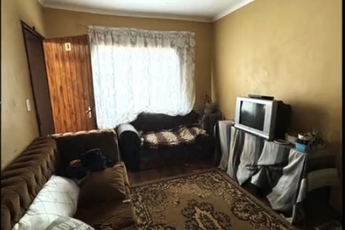 A living room space featuring a timber door and ceiling tiles, requiring cosmetic updates to improve the overall condition and aesthetic appeal.