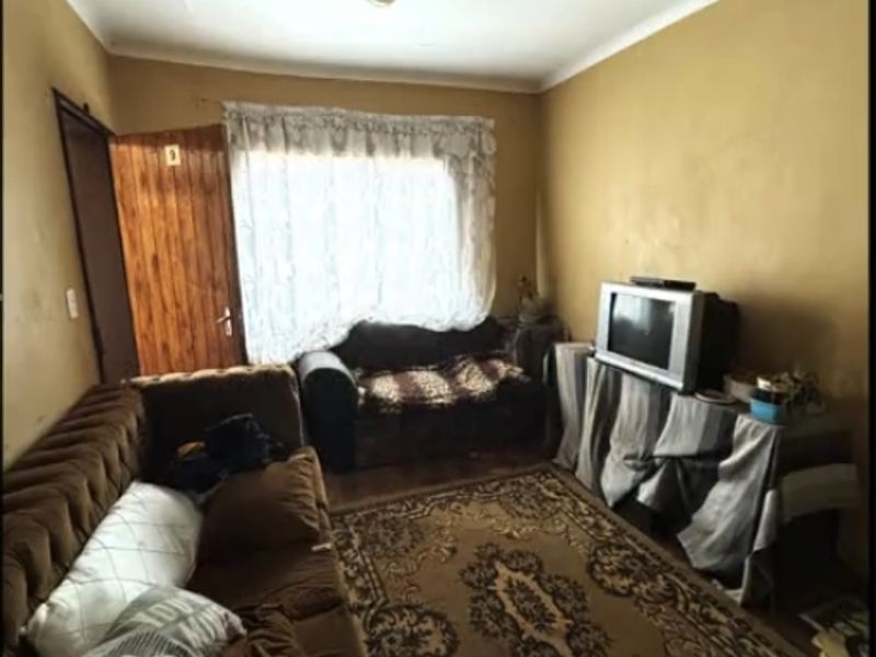 A living room space featuring a timber door and ceiling tiles, requiring cosmetic updates to improve the overall condition and aesthetic appeal.