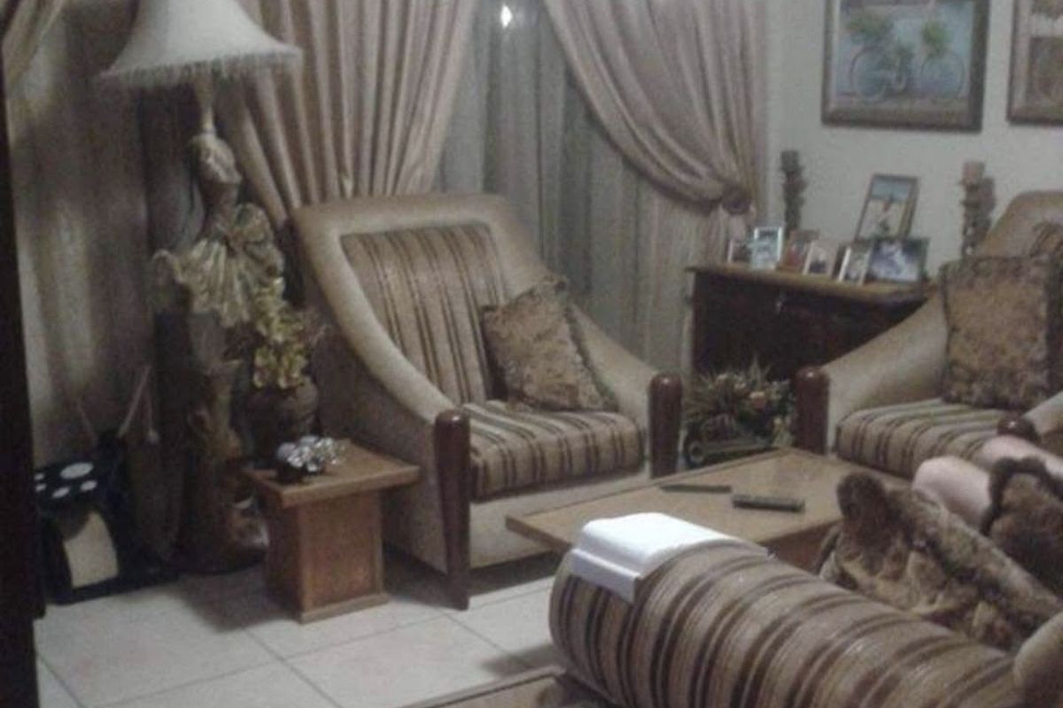 A living room area featuring tiled flooring and window treatments.