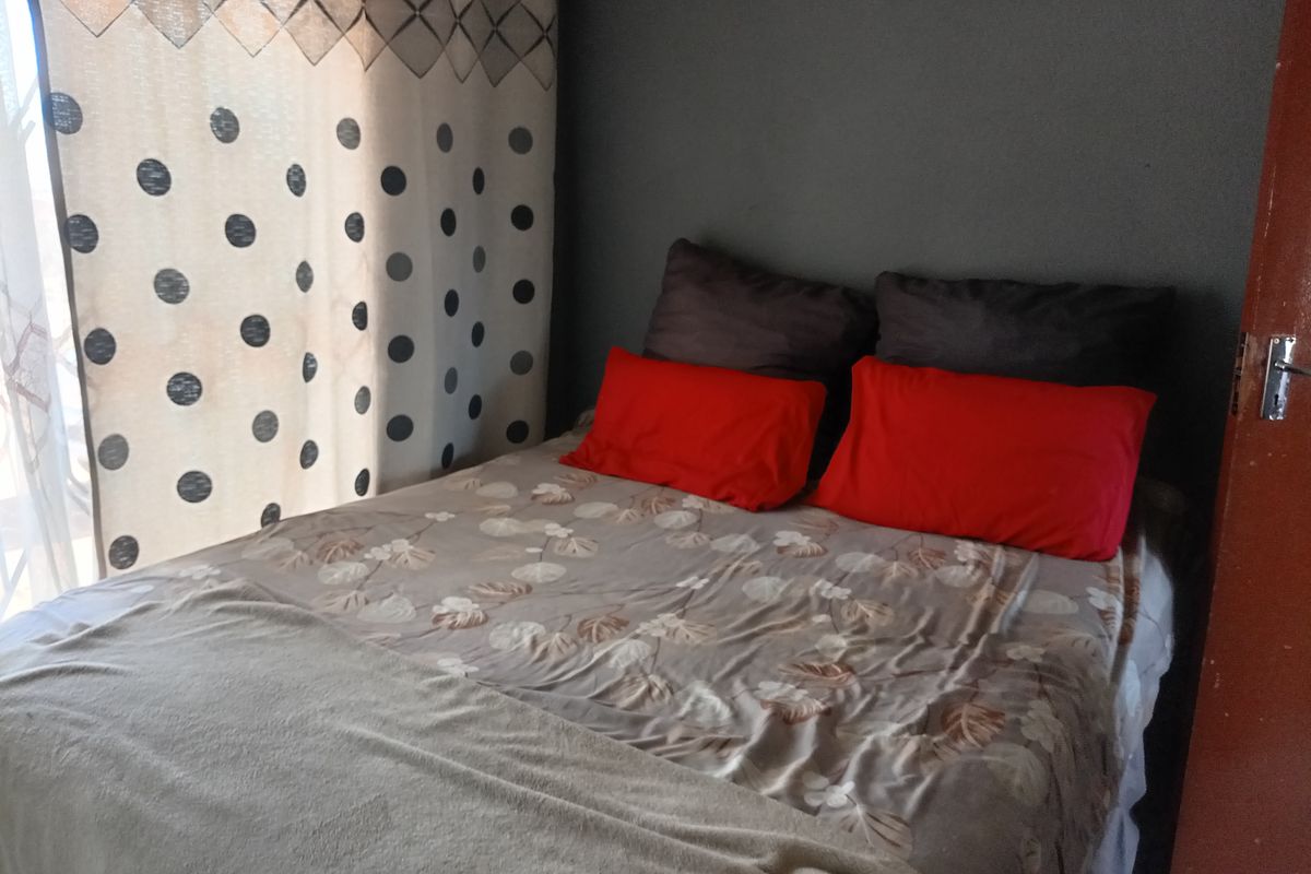 A standard bedroom featuring a sliding door providing natural light and access to the exterior.