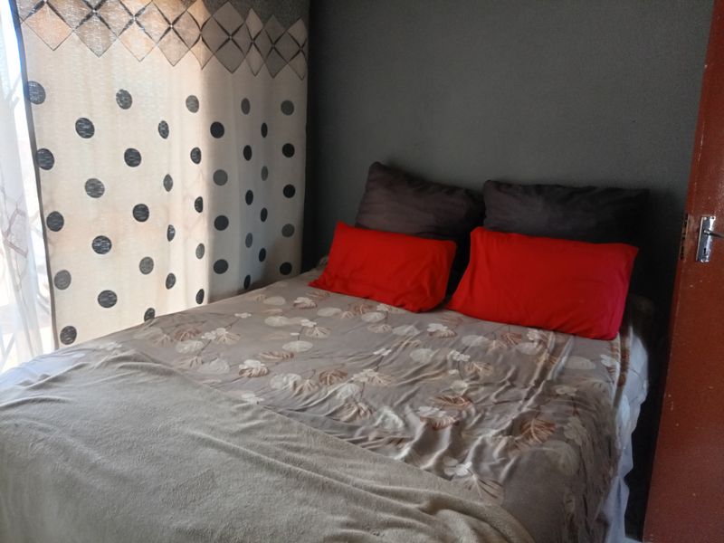 A standard bedroom featuring a sliding door providing natural light and access to the exterior.