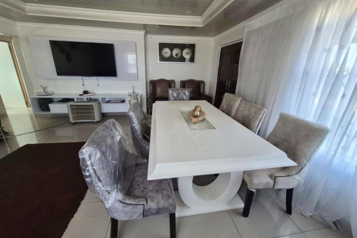 Spacious living and dining area featuring polished tiled flooring, a recessed ceiling design, and a modern built-in media console.